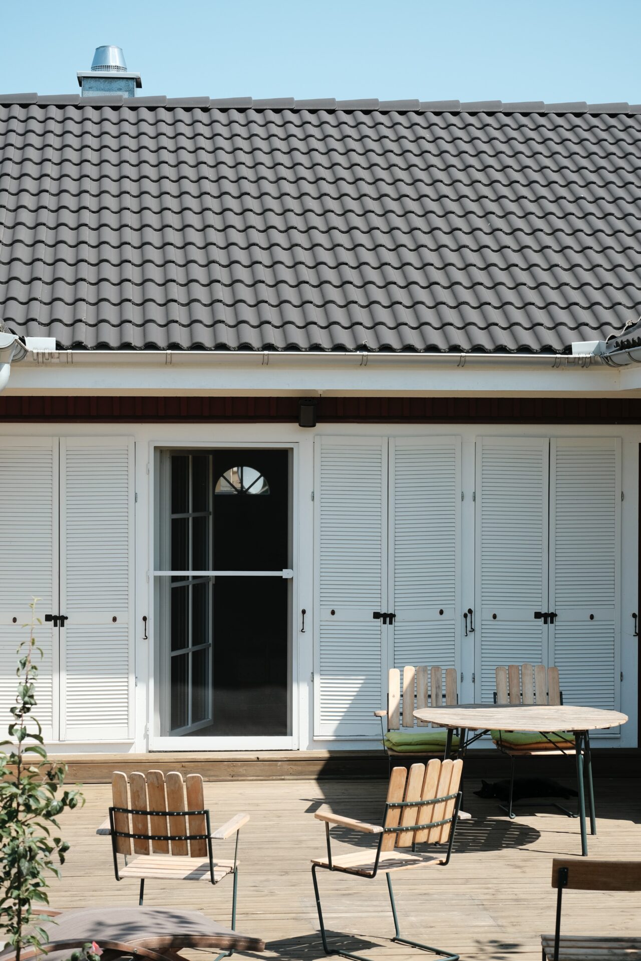 Maison avec toit en tuiles couleur ardoise et volets blanc